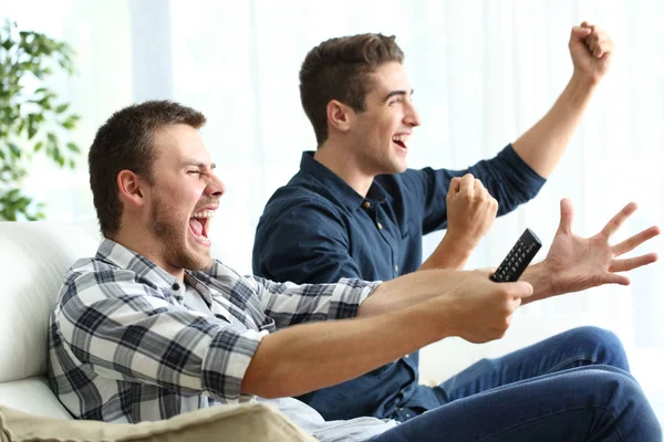 Compagni di stanza eccitati a guardare la tv a casa — Foto Stock