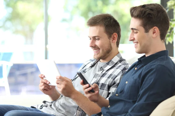 Tablet ve telefon kullanarak mutlu oda arkadaşı — Stok fotoğraf