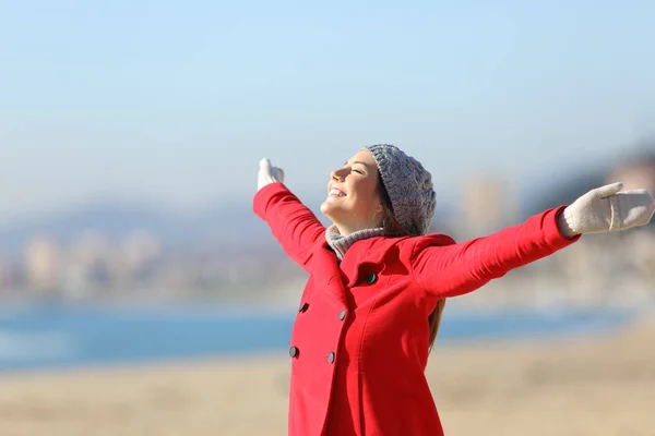 Šťastná žena dýchání kypřicími ruce v zimě — Stock fotografie