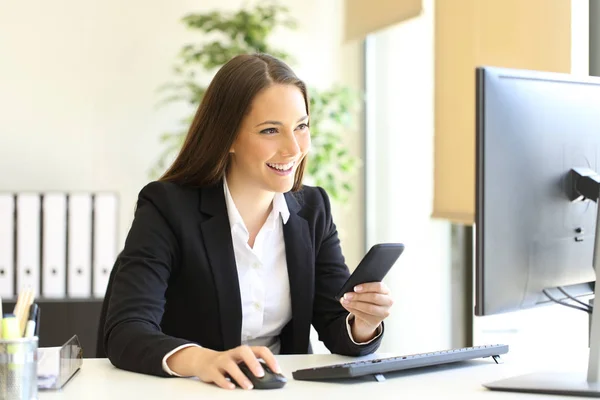 Businesswoman working with phone and computer — Stock Photo, Image