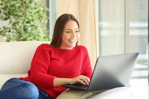 Щаслива жінка використовує ноутбук вдома — стокове фото