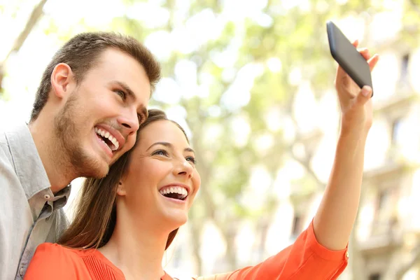 Happy couple taking selfies in the street — Stock Photo, Image