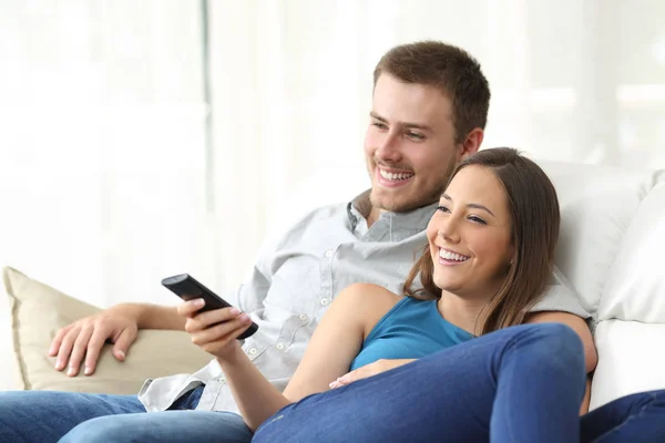 Счастливая пара смотрит телевизор дома — стоковое фото