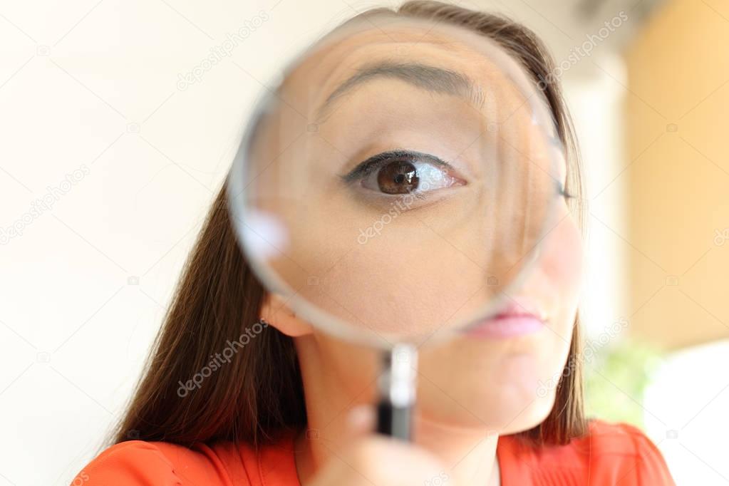 Businesswoman watching you with magnifier glass