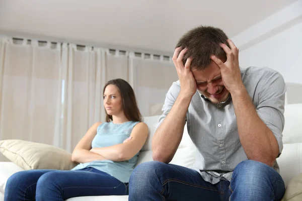Sad man and angry girlfriend at home — Stock Photo, Image