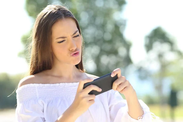 Menina jogando jogos no telefone inteligente — Fotografia de Stock