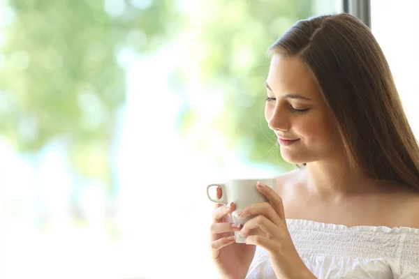 Романтичная девушка думает и смотрит на чашку кофе — стоковое фото