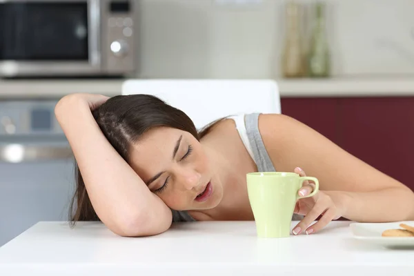 Tired girl sleeping at breakfast