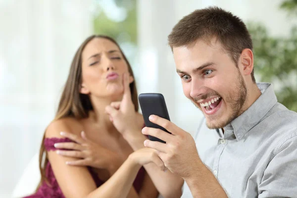 Man with a smart phone ignoring a sex proposal — Stock Photo, Image