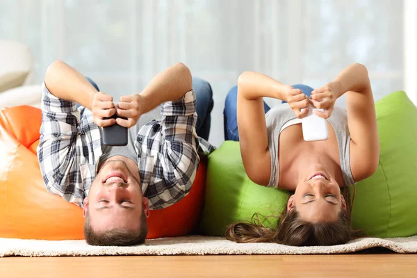 Compañeros de piso en línea con teléfonos inteligentes al revés —  Fotos de Stock