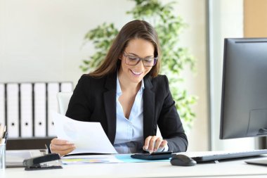 Ofiste hesap makinesi kullanan iş kadını
