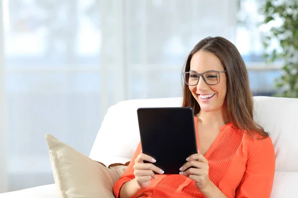 Woman wearing glasses reading a tablet — Stok fotoğraf