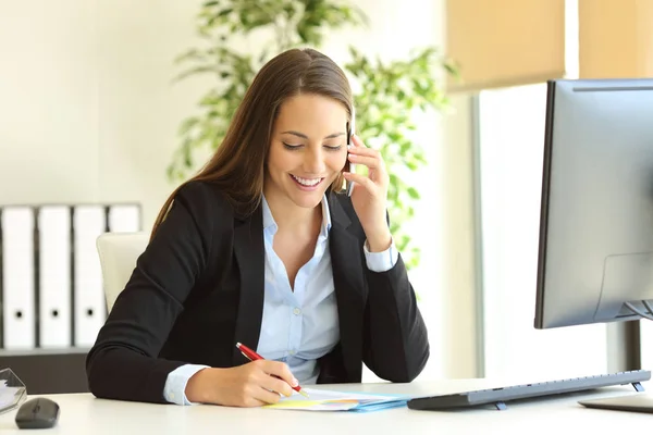 Businesswoman calling on phone and taking notes — Stock Photo, Image