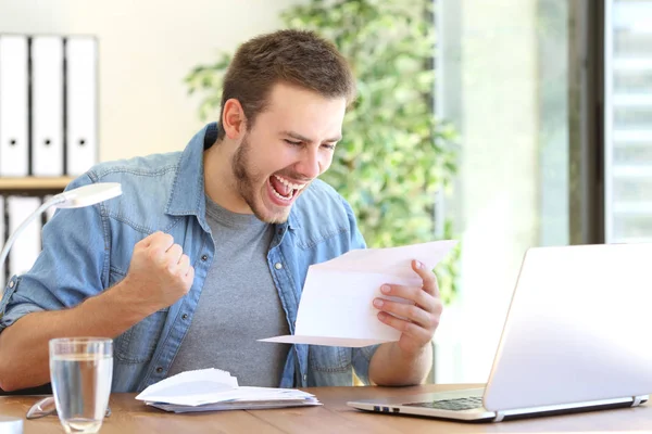 Excited entrepreneur reading a letter — Stock Photo, Image