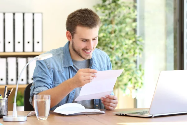 Happy entrepreneur reading a letter — Stock Photo, Image