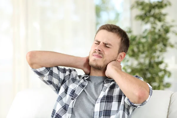 Uomo che soffre dolore al collo a casa — Foto Stock