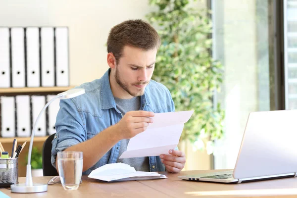Serious entrepreneur reading a letter — Stock Photo, Image