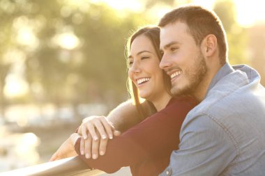 Günbatımında bir balkonda kucaklayan Çift