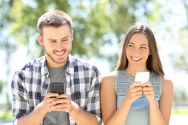 Friends flirting with phones in a frist date — Stock Photo, Image