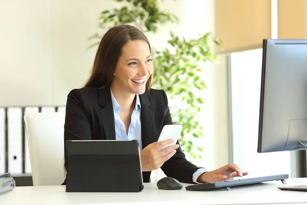 Happy businesswoman working with multiple devices