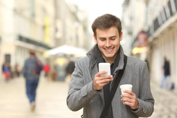 Geschäftsmann zu Fuß und mit Smartphone — Stockfoto