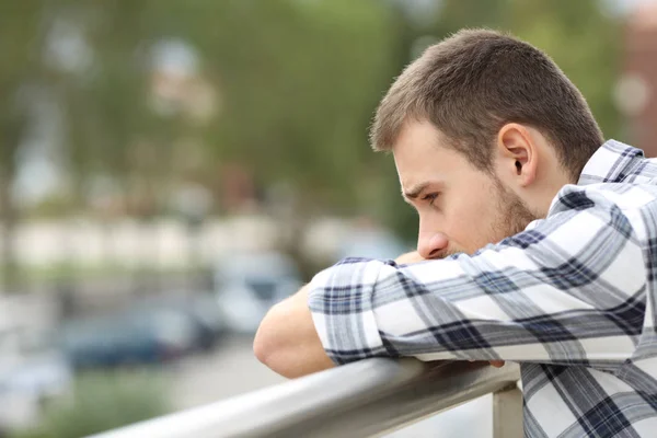 Triste homme regardant vers le bas depuis un balcon — Photo