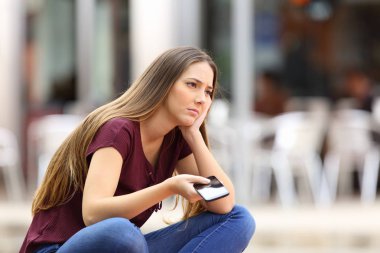 Üzgün kız cep telefonu arama için bekleniyor