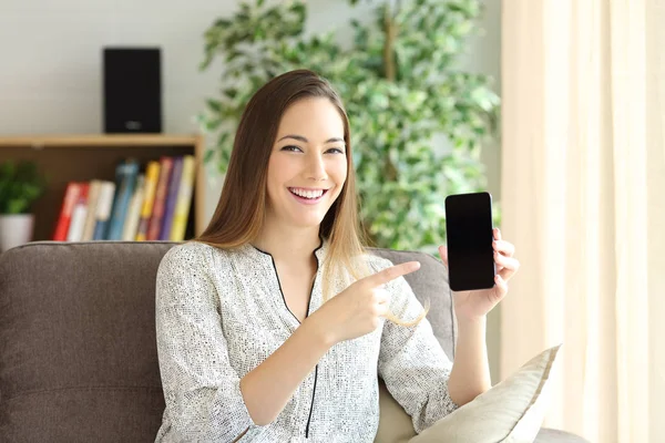 Frau zeigt Handybildschirm zu Hause — Stockfoto