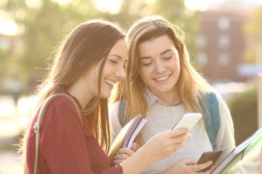 Bir akıllı telefon medyada izlerken öğrenciler