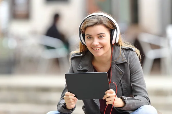 Mädchen mit Kopfhörer und Tablet schaut dich an — Stockfoto