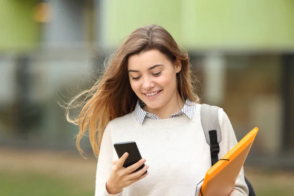 Estudiante caminando y leyendo mensajes telefónicos —  Fotos de Stock