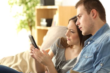 Üzgün çift bir telefon içeriğini denetleme