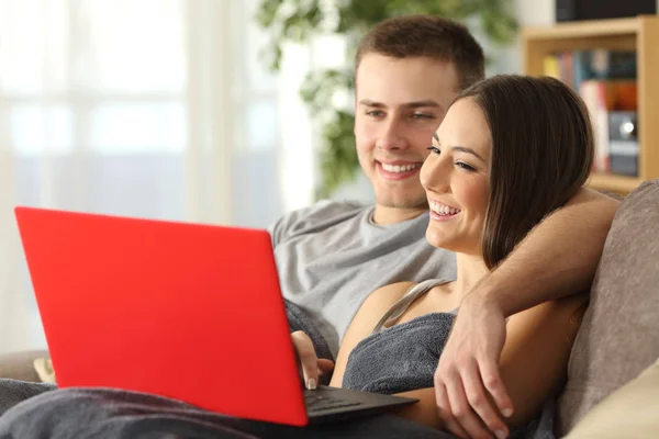 Ζευγάρι, περιήγηση στο internet σε ένα κόκκινο lap-top — Φωτογραφία Αρχείου