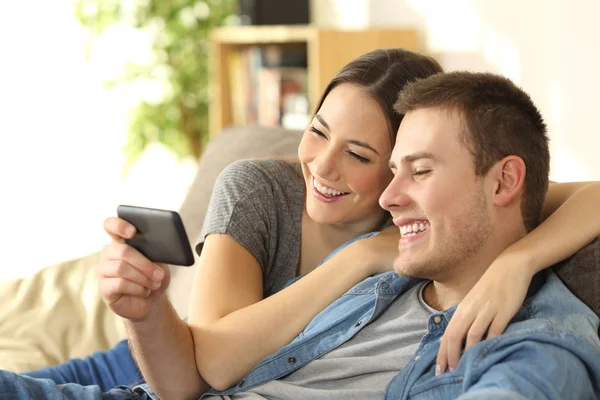 Casal gostando de assistir conteúdo de mídia em um telefone — Fotografia de Stock