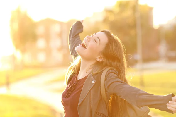 Excited girl raising arms in the street — Stock Photo, Image