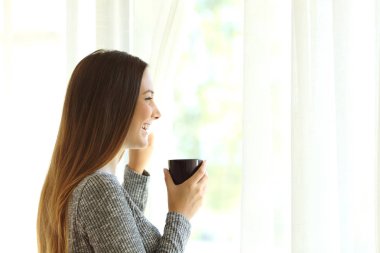 Kadın evde pencereden bakarak rahatlatıcı