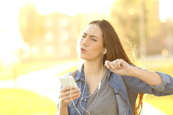 うれしそうな女性は、スマート フォンから音楽を聴く — ストック写真