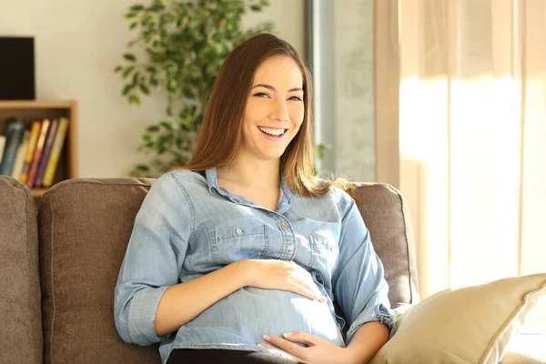 Mujer embarazada mirando a la cámara en casa — Foto de Stock