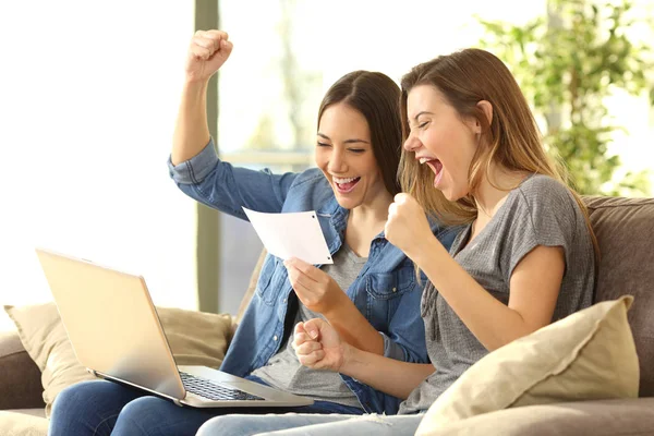 Compañeros de cuarto emocionados leyendo una notificación bancaria —  Fotos de Stock