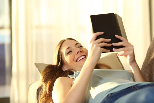 Wanita membaca e book berbaring di sofa — Stok Foto