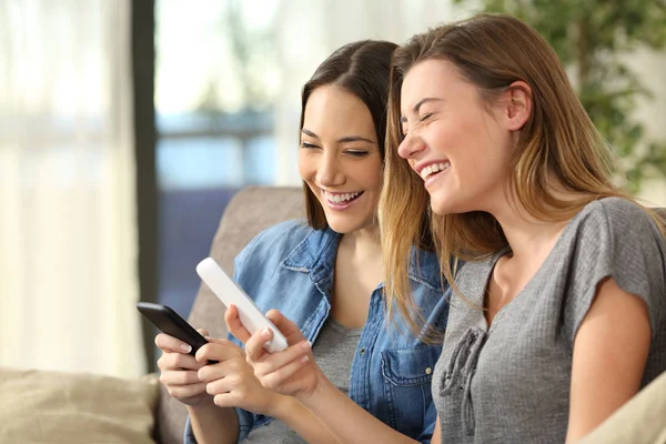 Chicas riendo viendo contenido multimedia en línea —  Fotos de Stock
