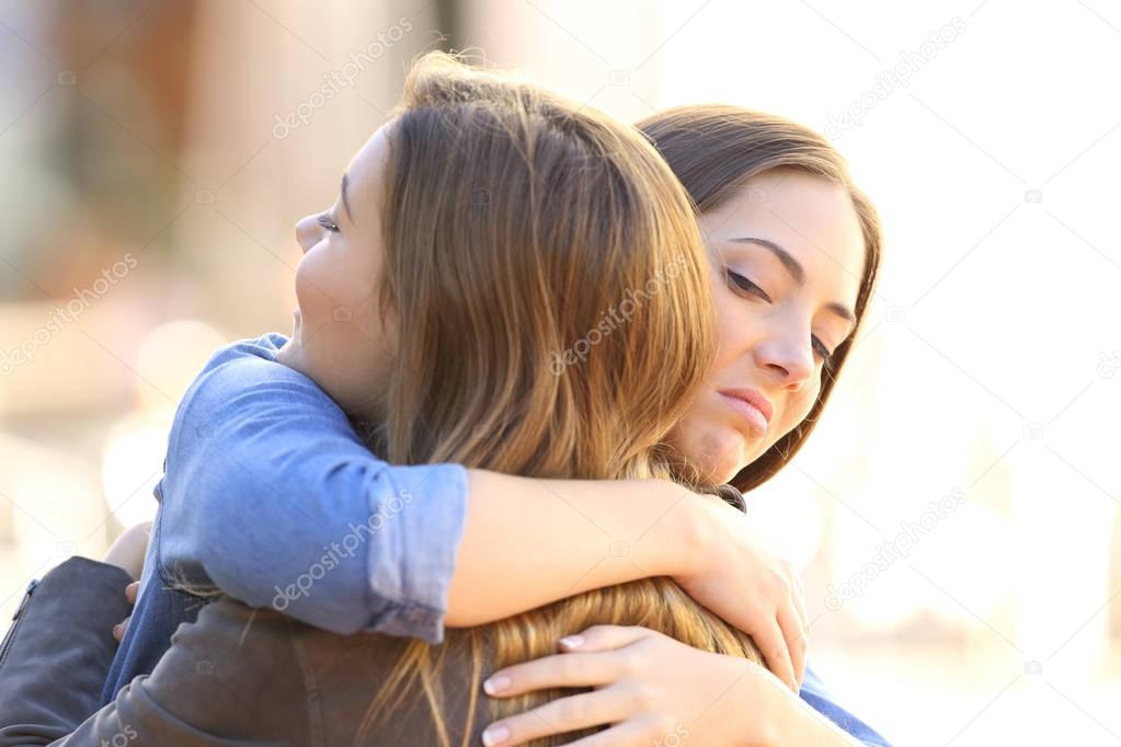 Hypocritical girl embracing a friend