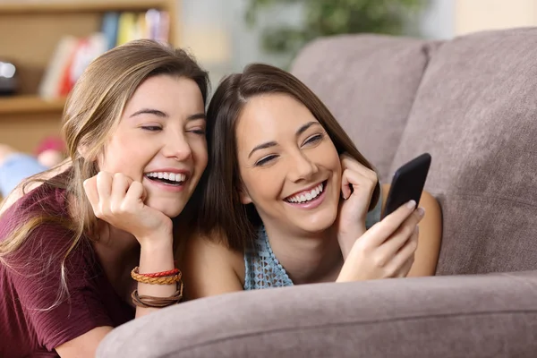 İki arkadaş bir akıllı telefon medya içeriklerinde izlerken — Stok fotoğraf