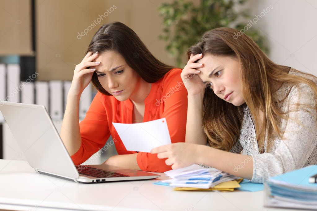 Worried coworkers reading a letter