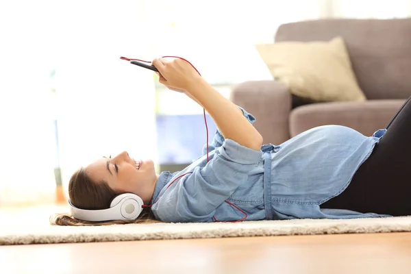 Wanita hamil mendengarkan musik dengan headphone — Stok Foto