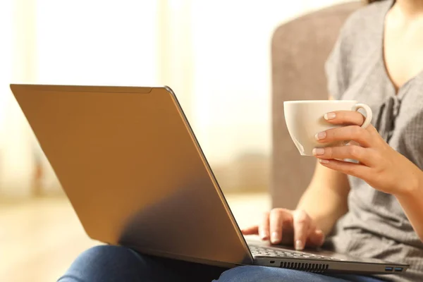 Mulher relaxante com um laptop e xícara de café — Fotografia de Stock