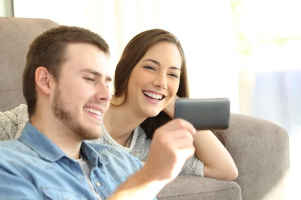 Casal assistindo conteúdo de mídia em um telefone inteligente — Fotografia de Stock