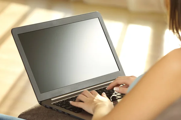 Girl using laptop and showing a blank monitor — Stock Photo, Image
