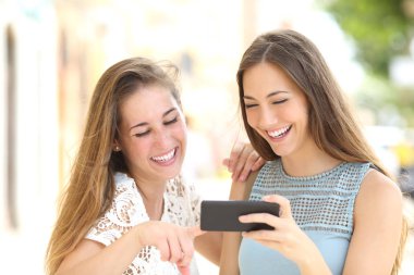 İki arkadaş bir akıllı telefon medya içeriklerinde izlerken
