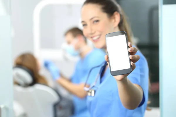 Female dentist showing phone screen — Stock Photo, Image